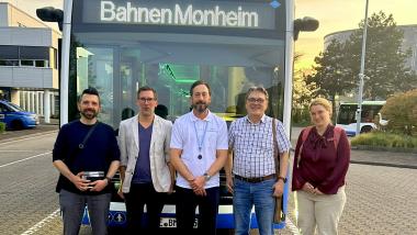 Vertreter der FDP und BSM vor einem Mercedes Elektro-Bus